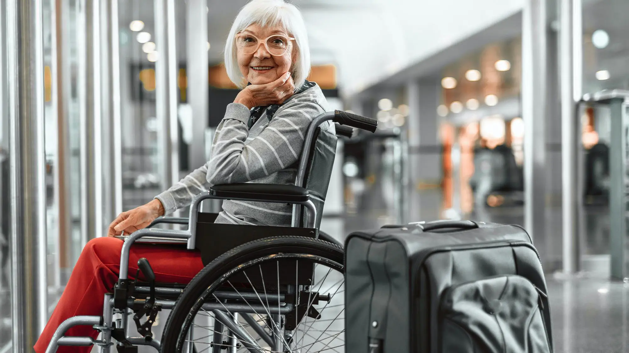 Woman in wheelchair with luggage in Nexus Airlines airport