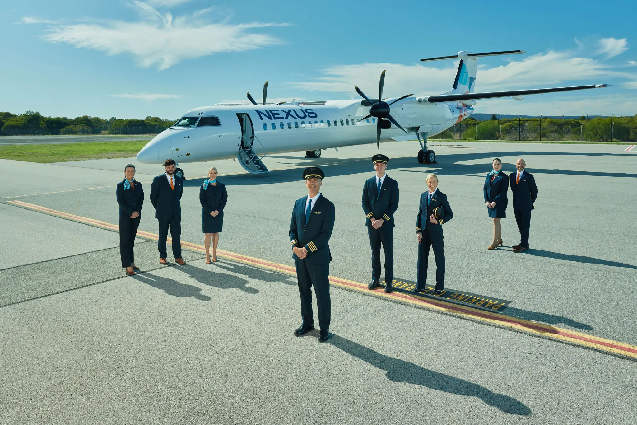 Nexus Airlines crew posing in front of a Nexus airplane