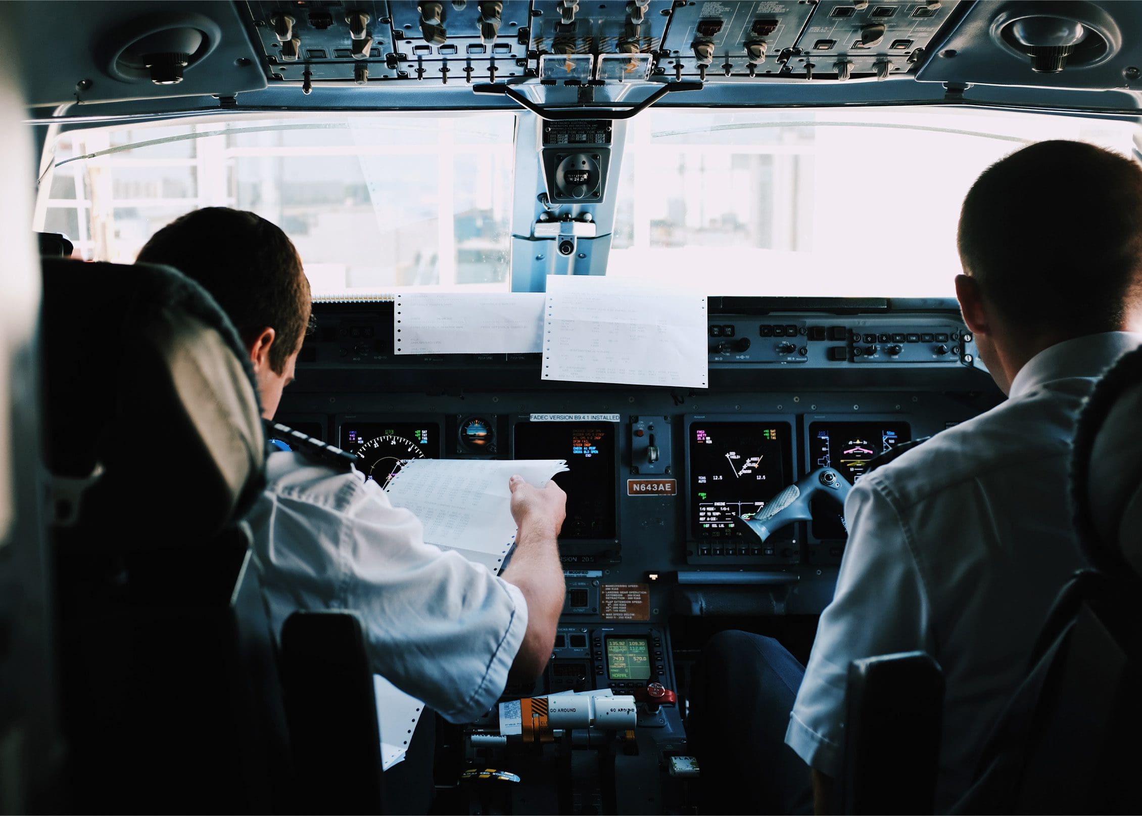 Two pilots sat in the cockpit of a Nexus Airlines plane overlooking documents